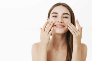 young woman applying facial cream face