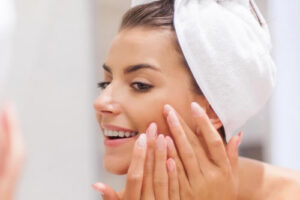 Young woman treating a pimple on her face