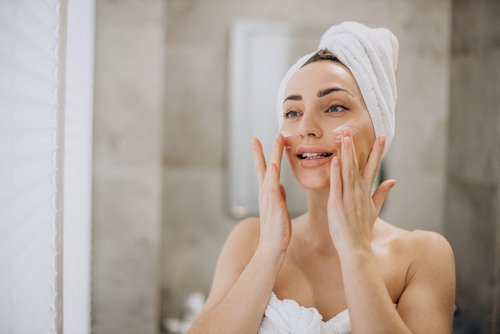 Young woman treating a pimple on her face